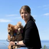 Johanna Markola sylissään kaksi ruskeaa villakoiraa