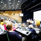 Valtuuston jäseniä istumassa täydessä valtuustosalissa