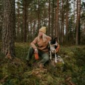 Nainen ja koira metsässä