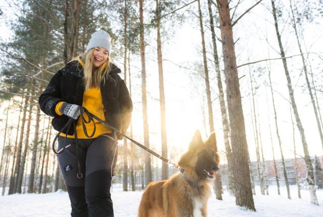 Nainen ja belgianpaimenkoira ulkoilemassa