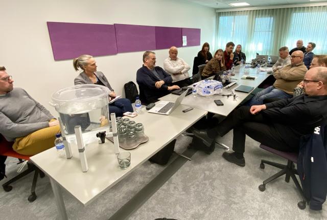 Metsästyskoiratyöryhmän sekä koe- ja kilpailutoimikunnan jäseniä ja sidosryhmien edustajia istumassa kokouspöydän ääressä.