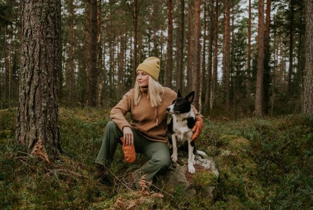 Nainen ja koira metsässä