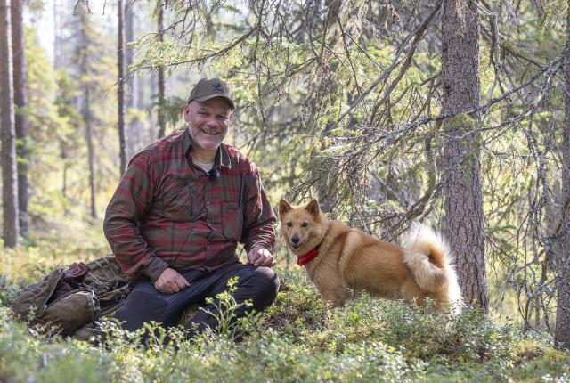 Blogin kirjoittaja Risto Ylitalo metsässä suomenpystykorvansa kanssa, istuu varvikossa hymyillen kameraan koira vierellään.
