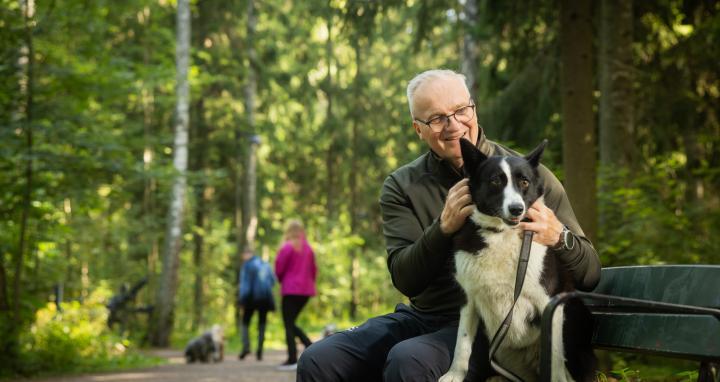 Mies ja koira istumassa penkillä