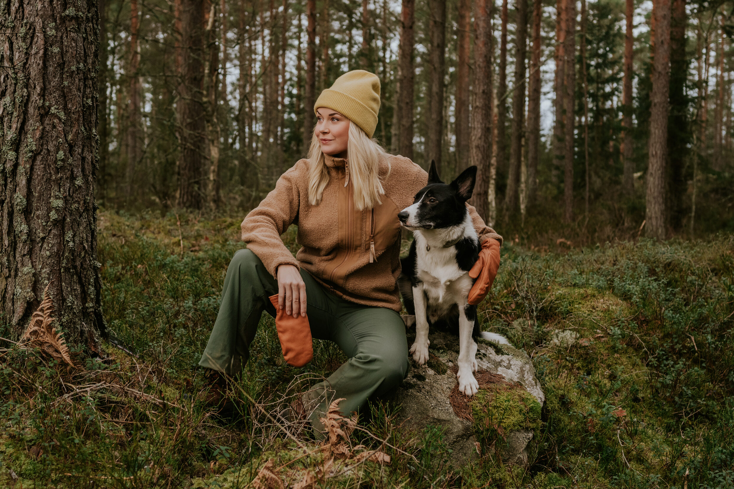 Nainen ja bordercollie metsässä